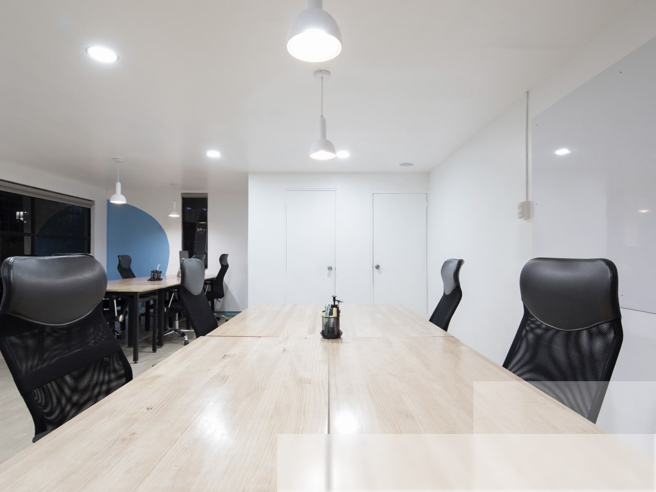an empty conference room with black chairs and a wooden table.
